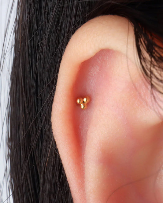 A pair of gold-colored stainless steel earrings with a geometric design, featuring three spherical elements connected by a central point in ear