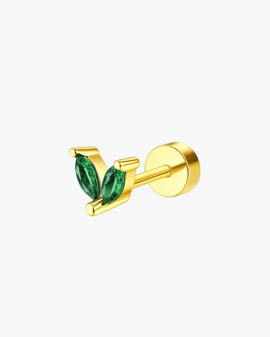 Gold earring with green gemstones on a white background
