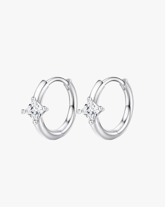 A pair of silver-colored hoop earrings with a small clear crystal in the center.