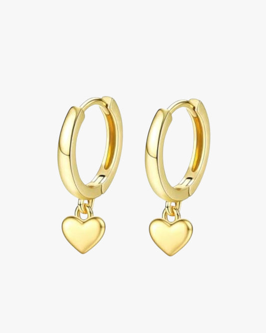 A pair of gold-colored hoop earrings with heart charms attached, displayed against a white background.
