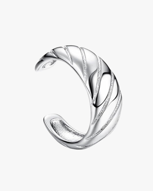 A single cuff earring with a curved design, against a white background.