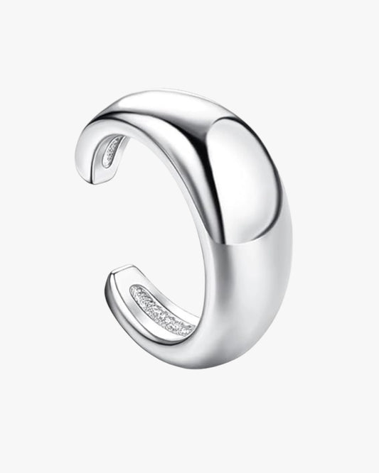 A silver cuff with a curved, loop-shaped design, intended for pierced ears.