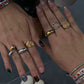 Close-up of two hands wearing multiple rings with various designs.