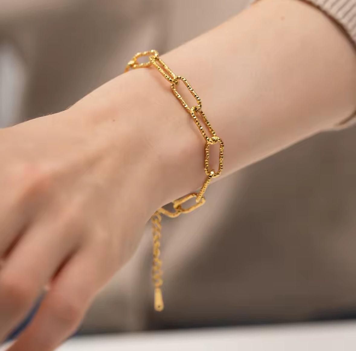 Gold bracelet on a wrist with a blurred background