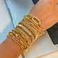 Gold bracelets on a wrist with a blurred background