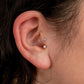 Close-up of an ear with two diamond stud earrings.