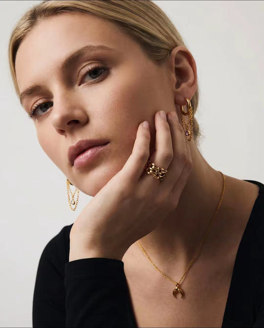 Gold chain hoop earrings worn in ear with crystal drop