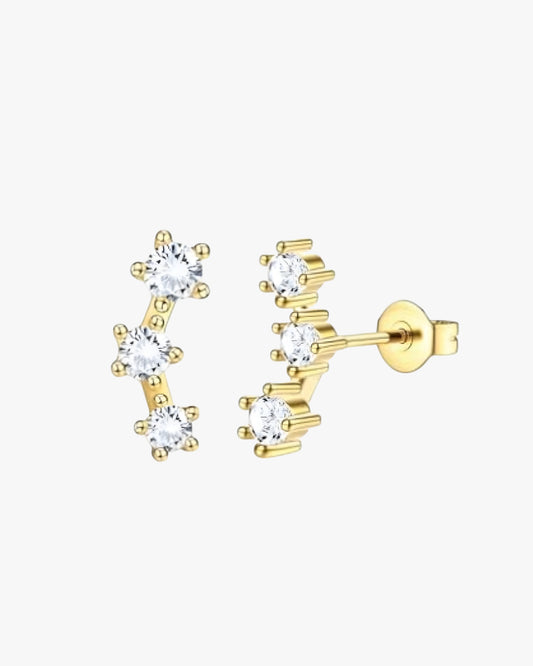Gold earrings with clear gemstones on a white background