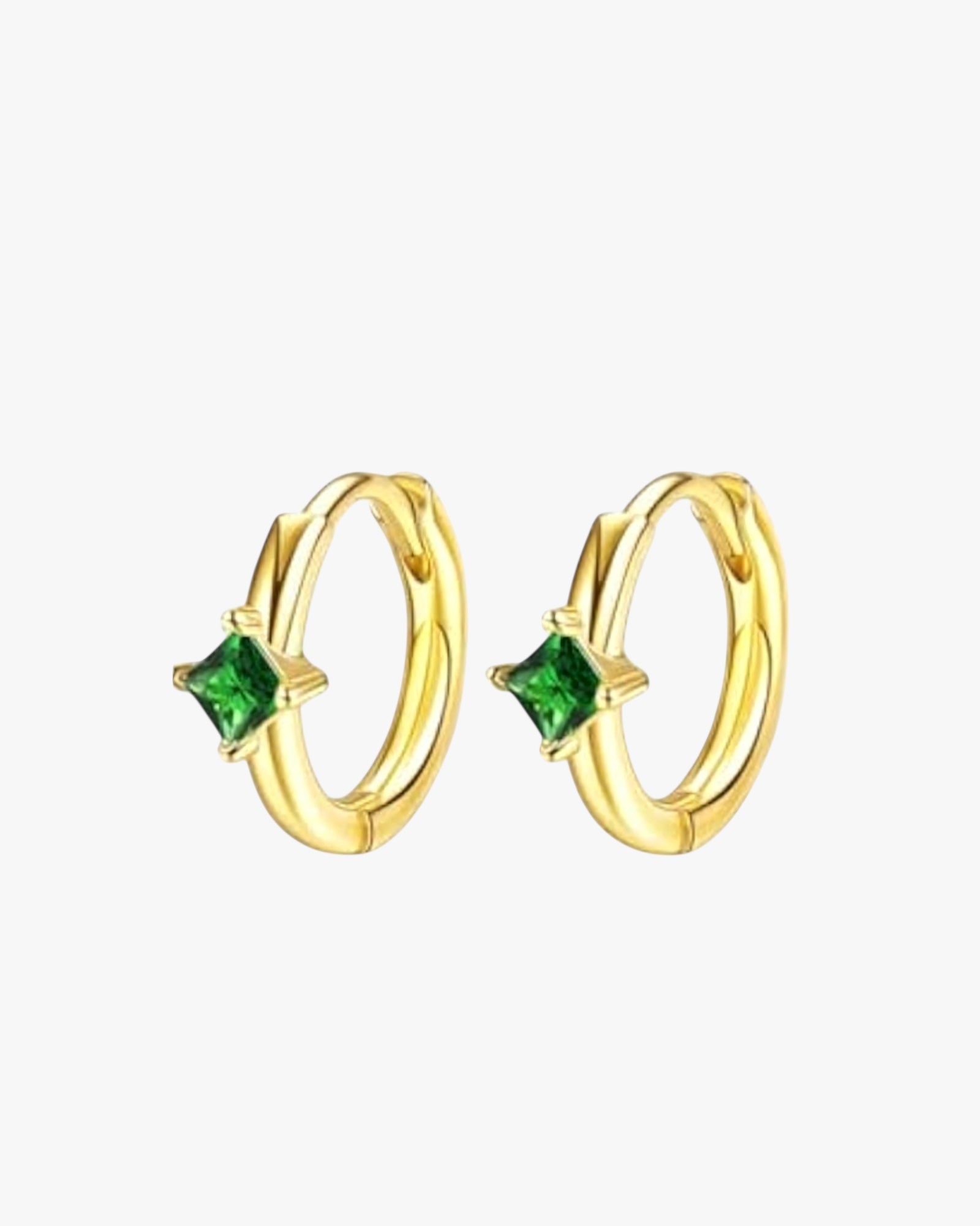 Gold hoop earrings with green gemstones on a white background