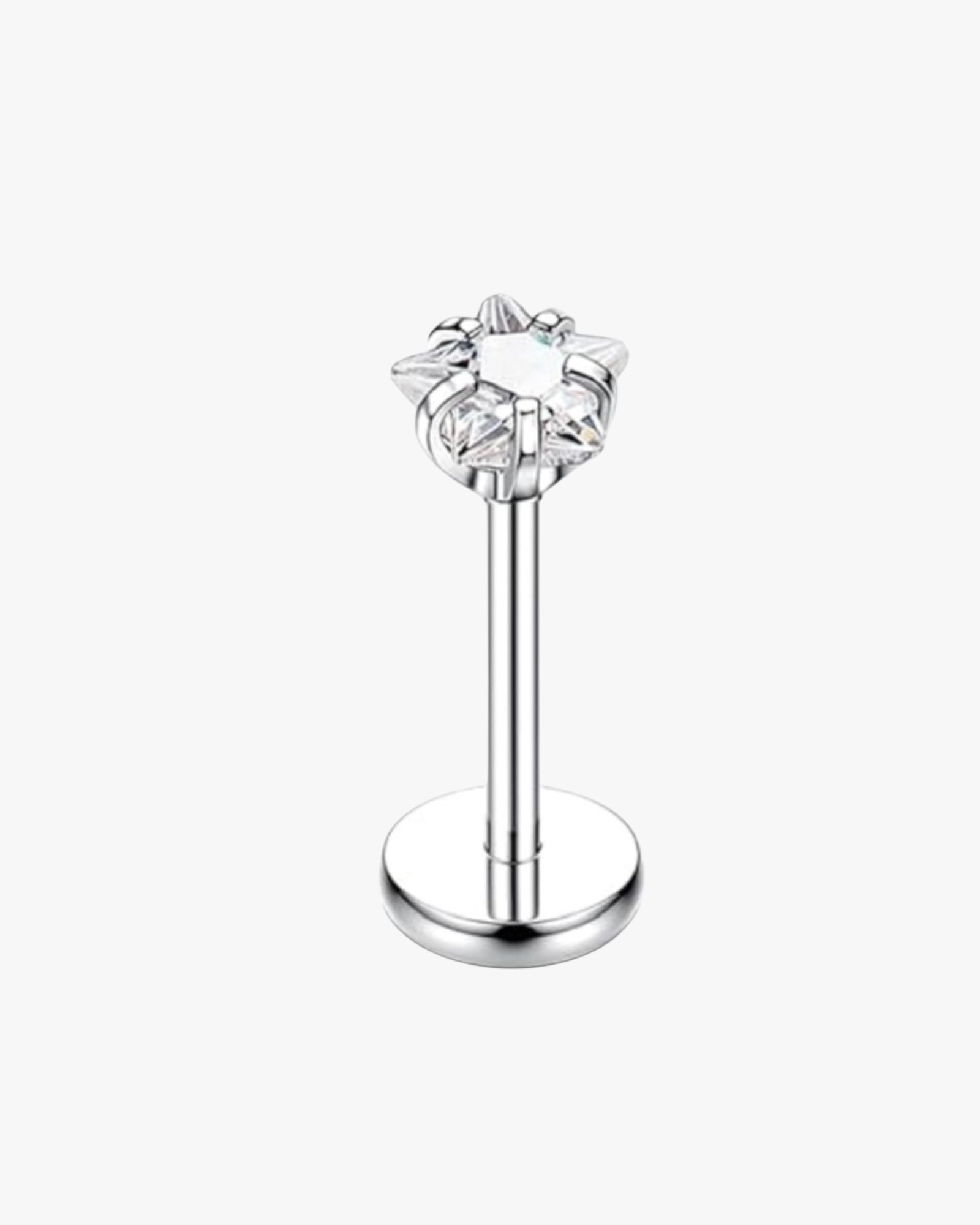 Silver lip ring with star-shaped gemstone on a white background
