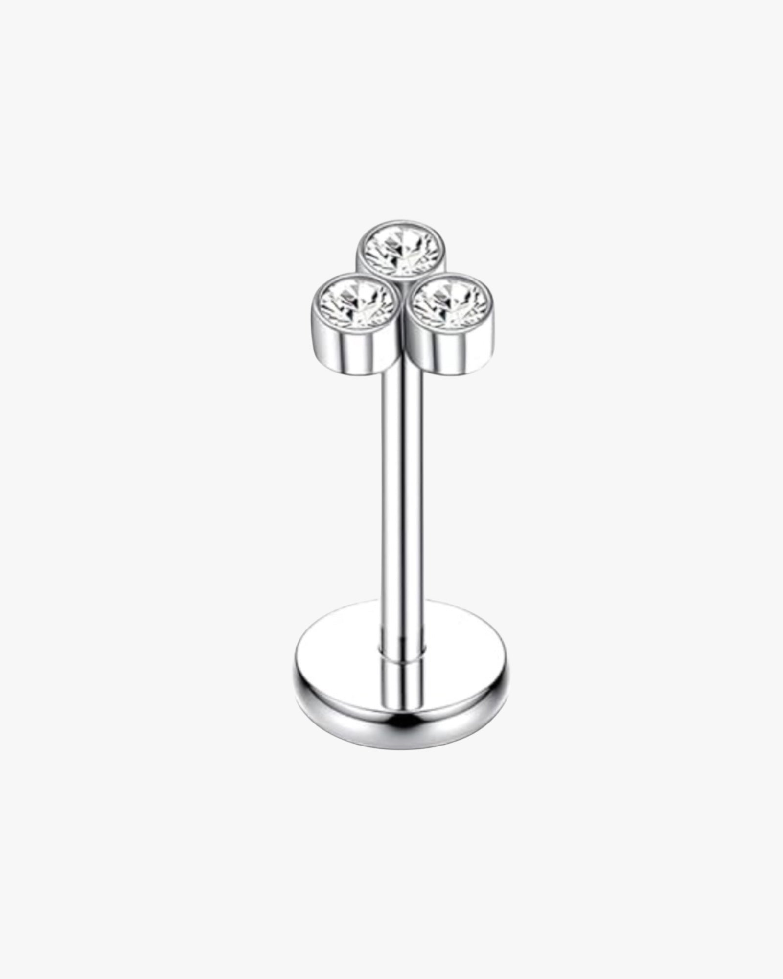 Silver earring with three clear gemstones on a white background