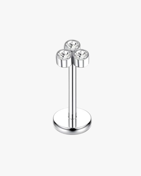 Silver earring with three clear gemstones on a white background