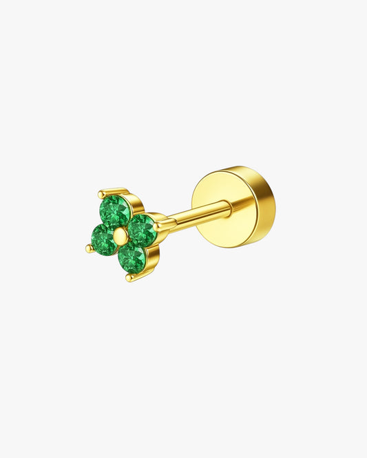 Gold earring with green gemstones on a white background