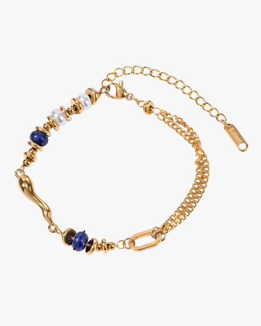Gold stainless steel 18k gold pvd plated bracelet with blue and white beads on a white background