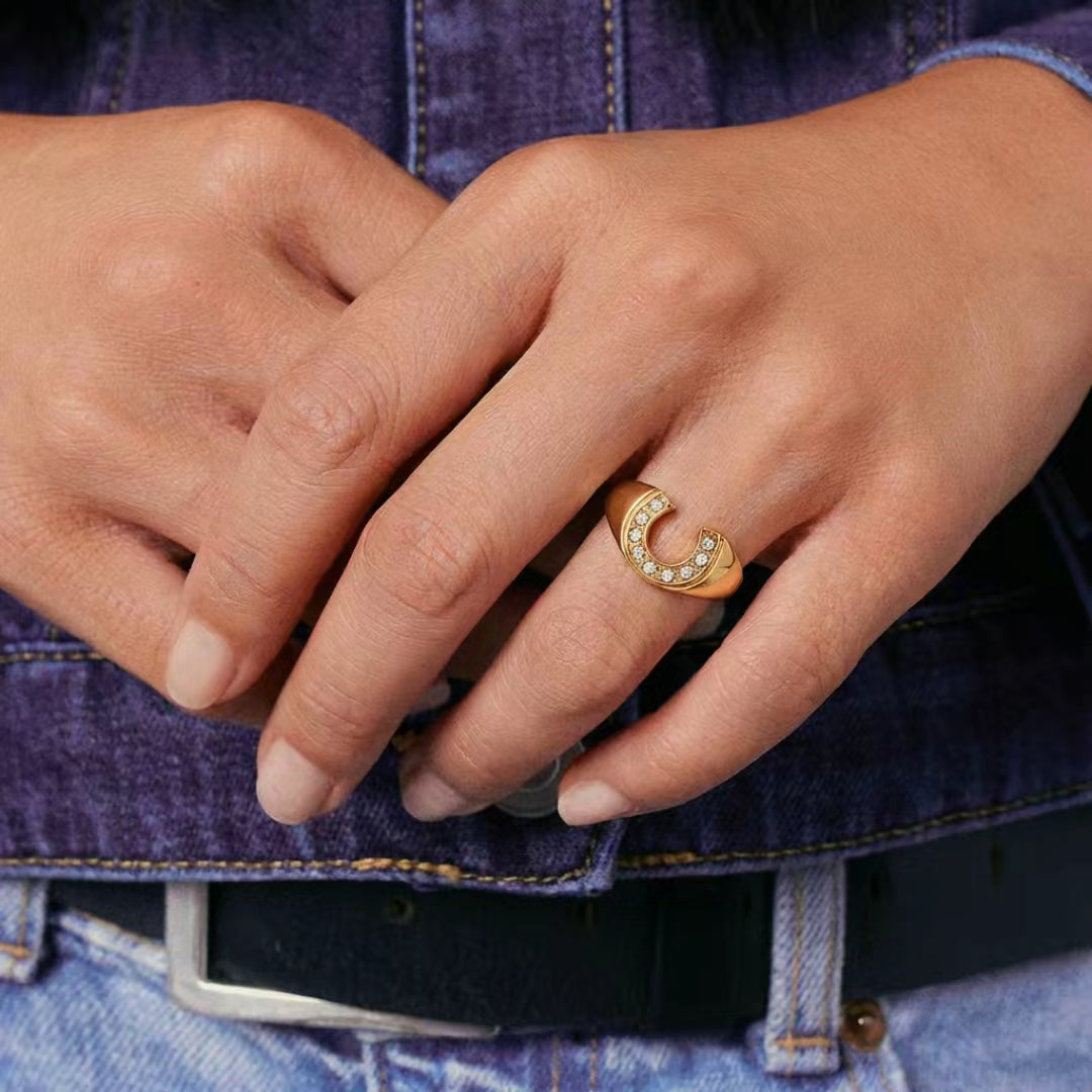 Close-up of hands with a gold ring on a denim background