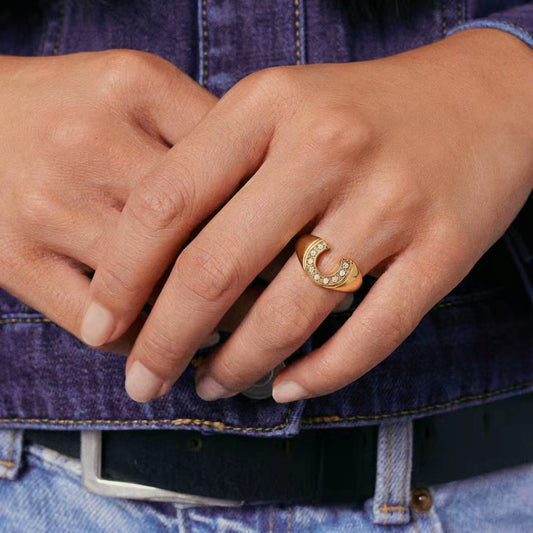 Close-up of hands with a gold ring on a denim background