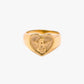 Gold heart-shaped ring with an engraved design on a white background