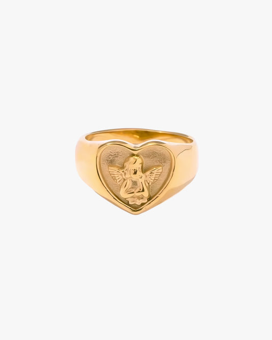 Gold heart-shaped ring with an engraved design on a white background