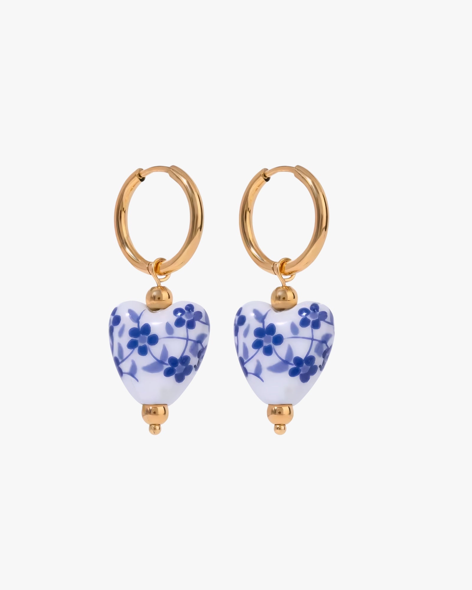 Pair of hoop earrings with heart-shaped blue floral drops on a white background