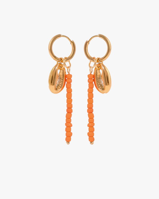 Gold hoop earrings with orange bead drops on a white background