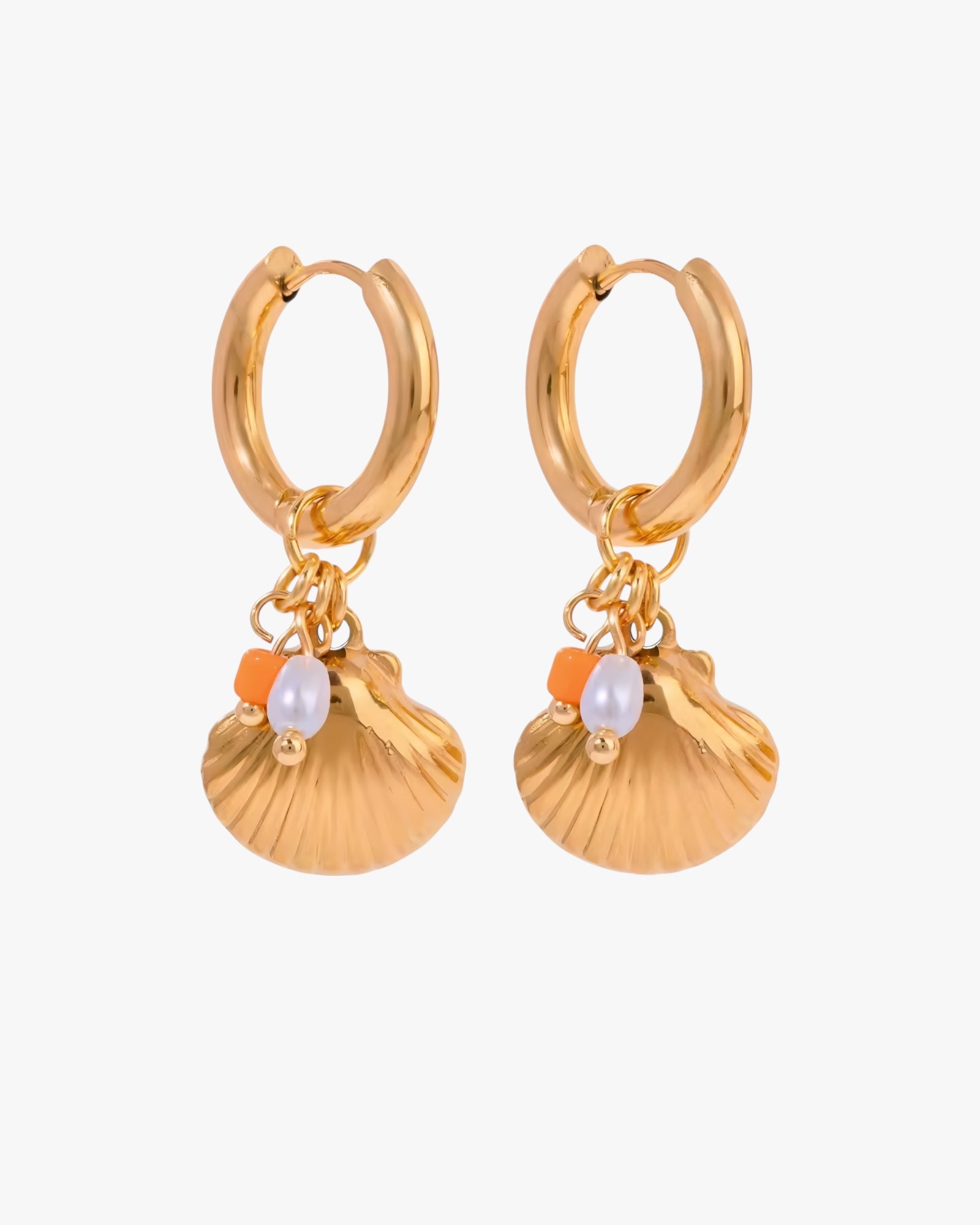 Gold hoop earrings with shell and pearl charms on a white background
