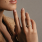 Close-up of a hand with a ring on a neutral background