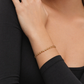Gold bracelet on a person's wrist with a black sleeve