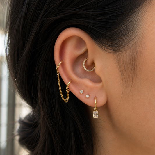 Close-up of an ear with multiple gold earrings