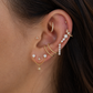 Close-up of an ear with multiple gold and pearl earrings.