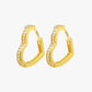 A pair of gold-colored hoop earrings with small, clear stones embedded along the hoop's length.