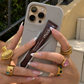 Person holding a phone with a Thode product, wearing multiple rings.