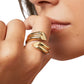 Close-up of a hand wearing two gold rings with a blurred background