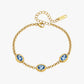 Gold bracelet with blue gemstones on a white background