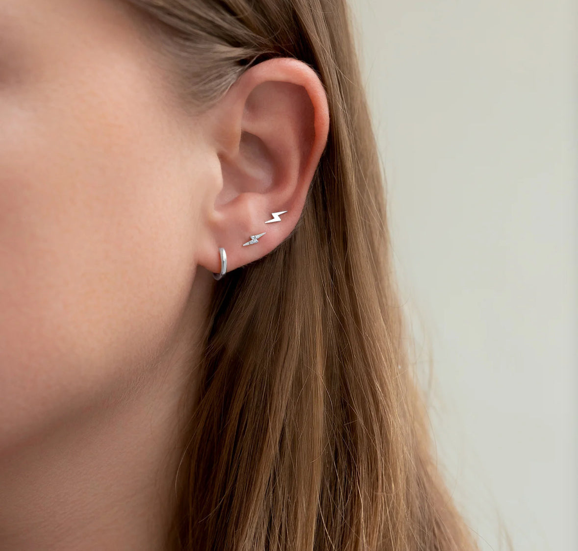 A single silver-colored stainless steel bolt stud in ear