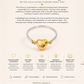 Amoura Ring with gold heart design on a beige background