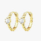 A pair of gold-colored hoop earrings with a small circular embellishment at the top, displayed against a white background.
