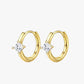 A pair of gold-colored hoop earrings with a small clear crystal in the center.