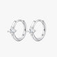A pair of silver-colored hoop earrings with a small clear crystal in the center.