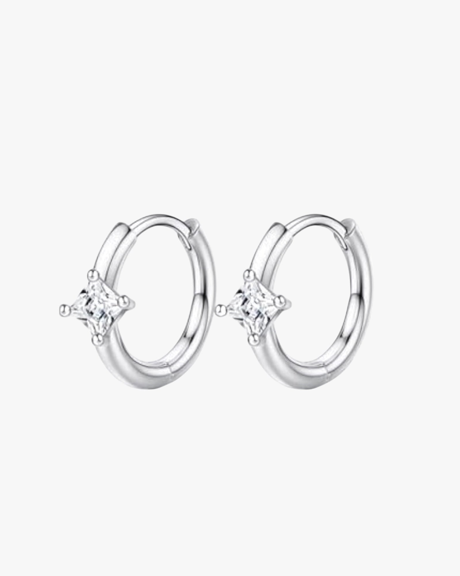 A pair of silver-colored hoop earrings with a small clear crystal in the center.