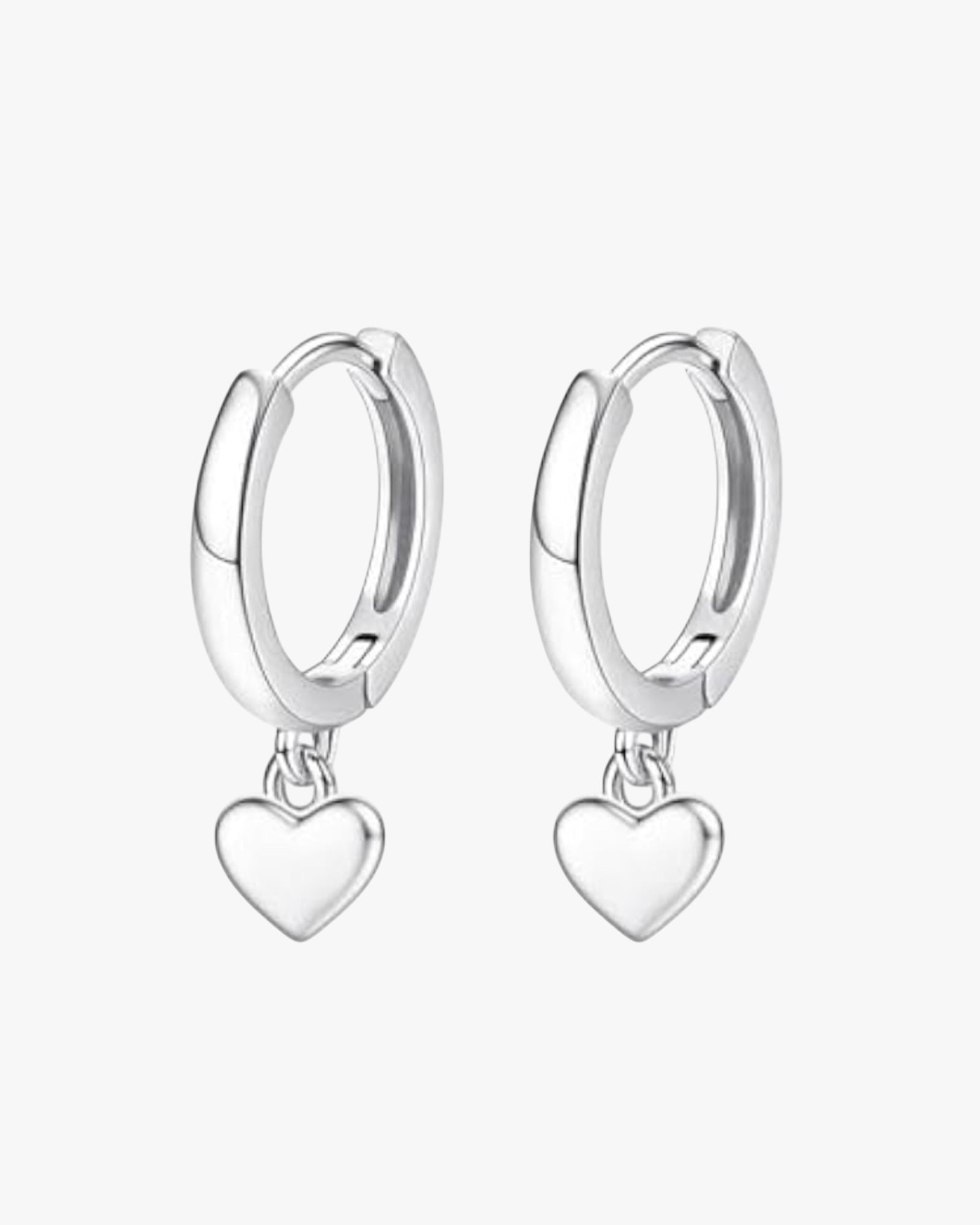 A pair of silver-colored hoop earrings with heart charms attached, displayed against a white background.