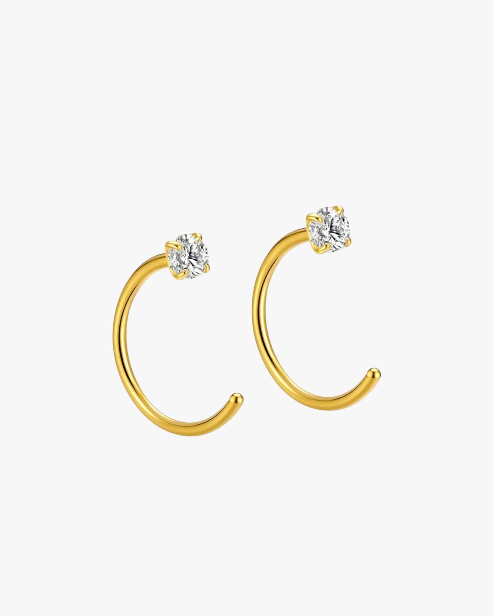 Gold hoop earrings with clear gemstones on a white background