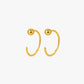 Gold hoop earrings with spherical ends on a white background