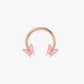 Rose gold half hoop with pink butterfly charms on a light pink background