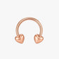 Rose gold hoop earring with heart-shaped ends on a light beige background