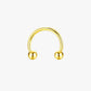Gold nose ring with two spherical ends on a white background