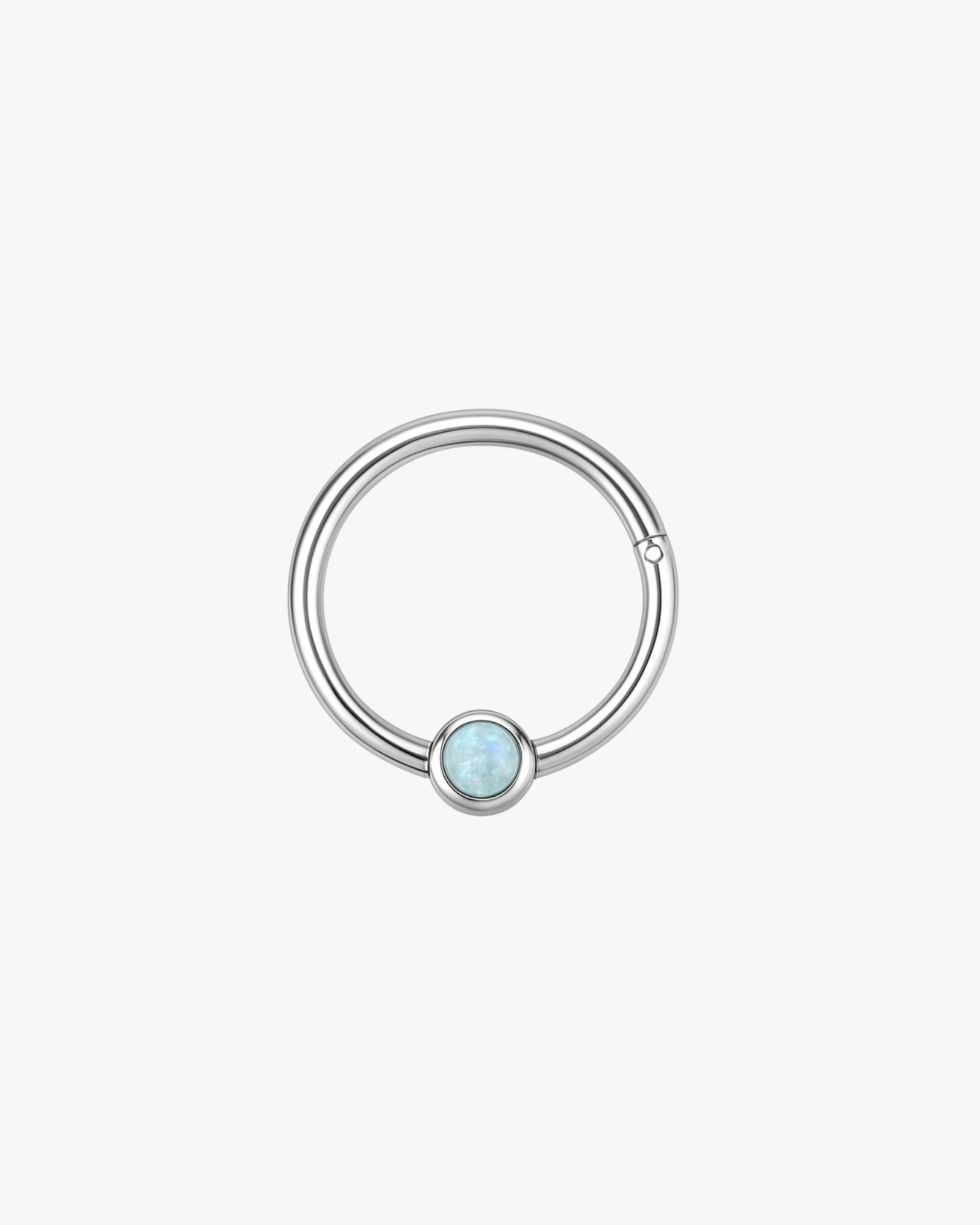 Silver ring with a blue gemstone on a white background