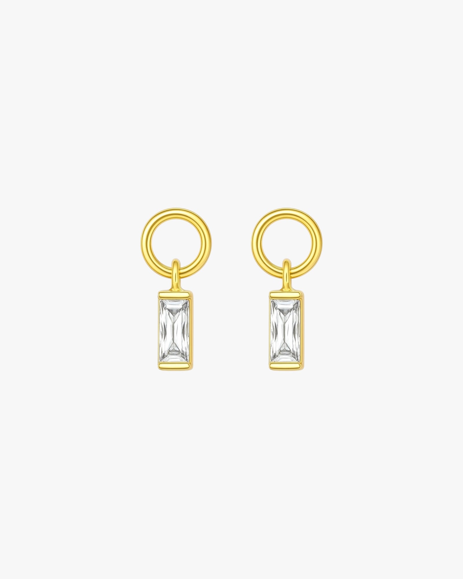 Gold earrings with rectangular gemstones on a white background