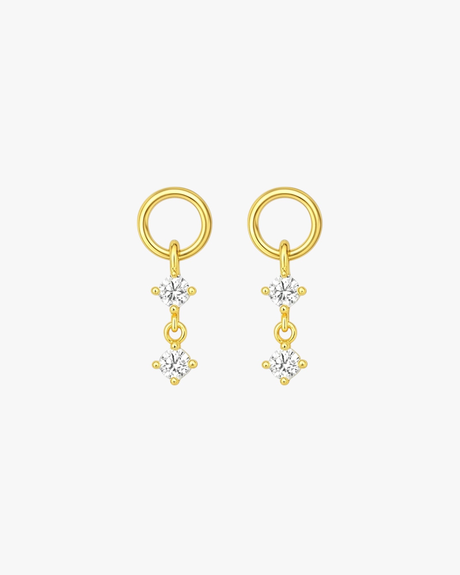 Gold earrings with three small diamonds on a white background