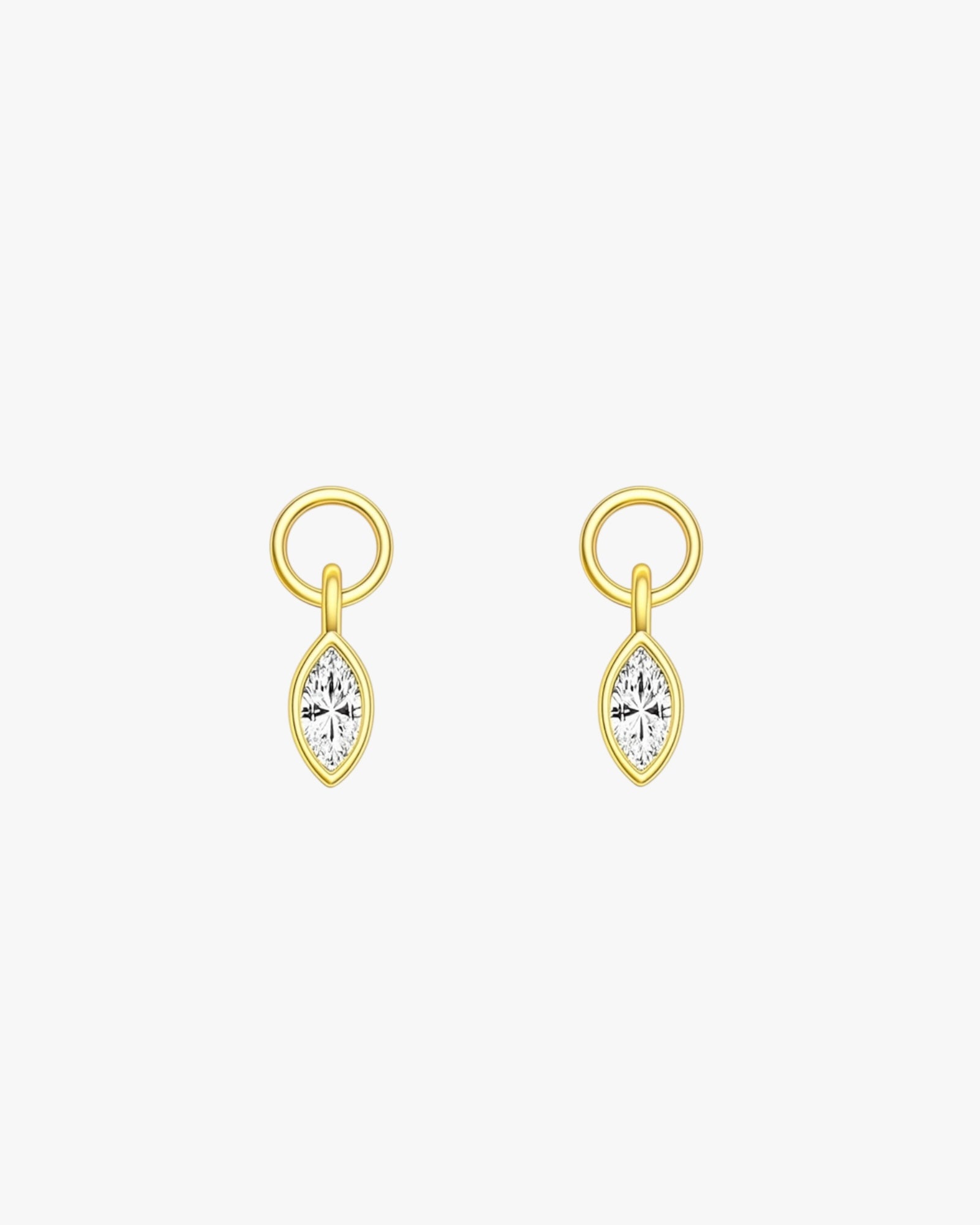 Gold earrings with clear gemstones on a white background