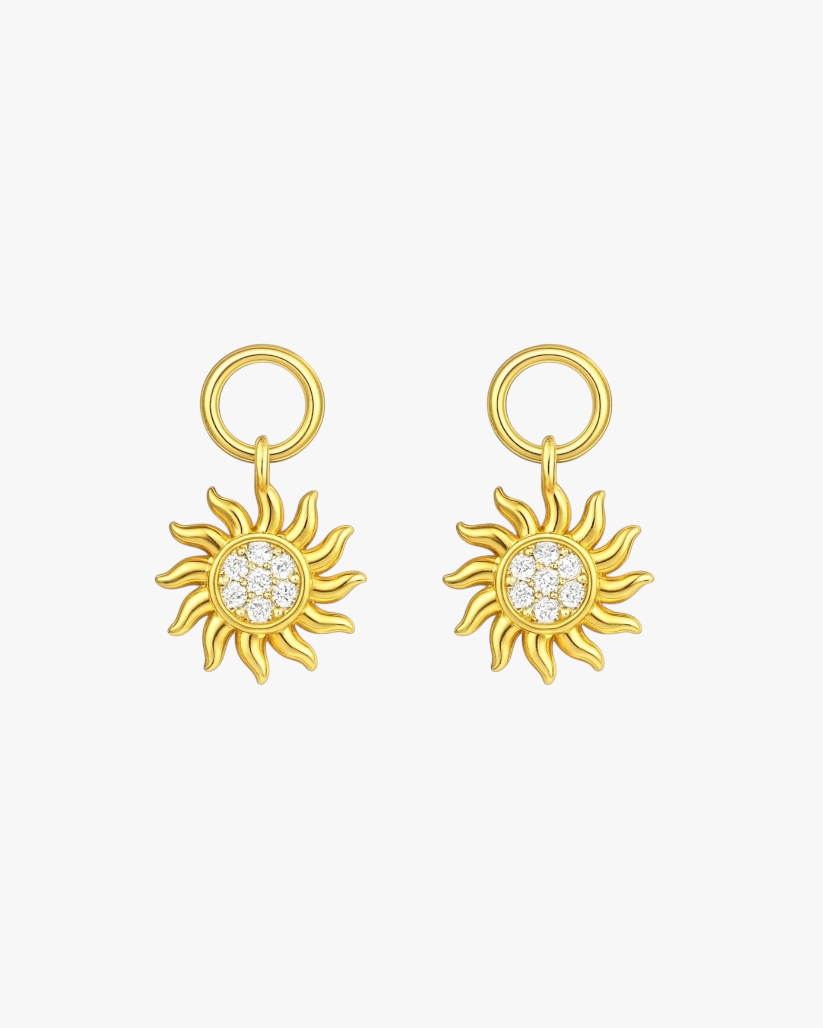 Gold sun-shaped earrings with gemstones on a white background